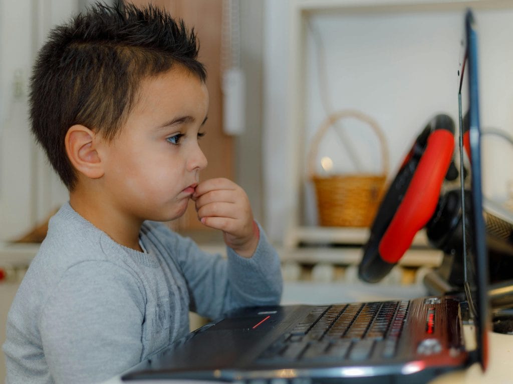 Child using a laptop for learning and education technology