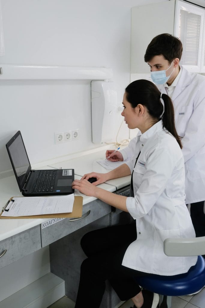 Medical professionals using a laptop in a clinic