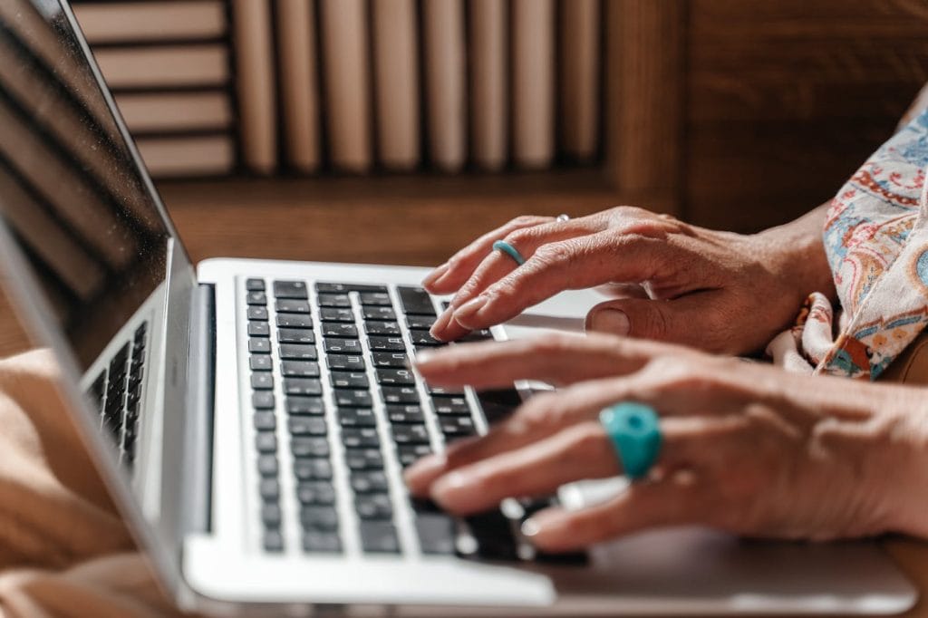Older person using a laptop keyboard